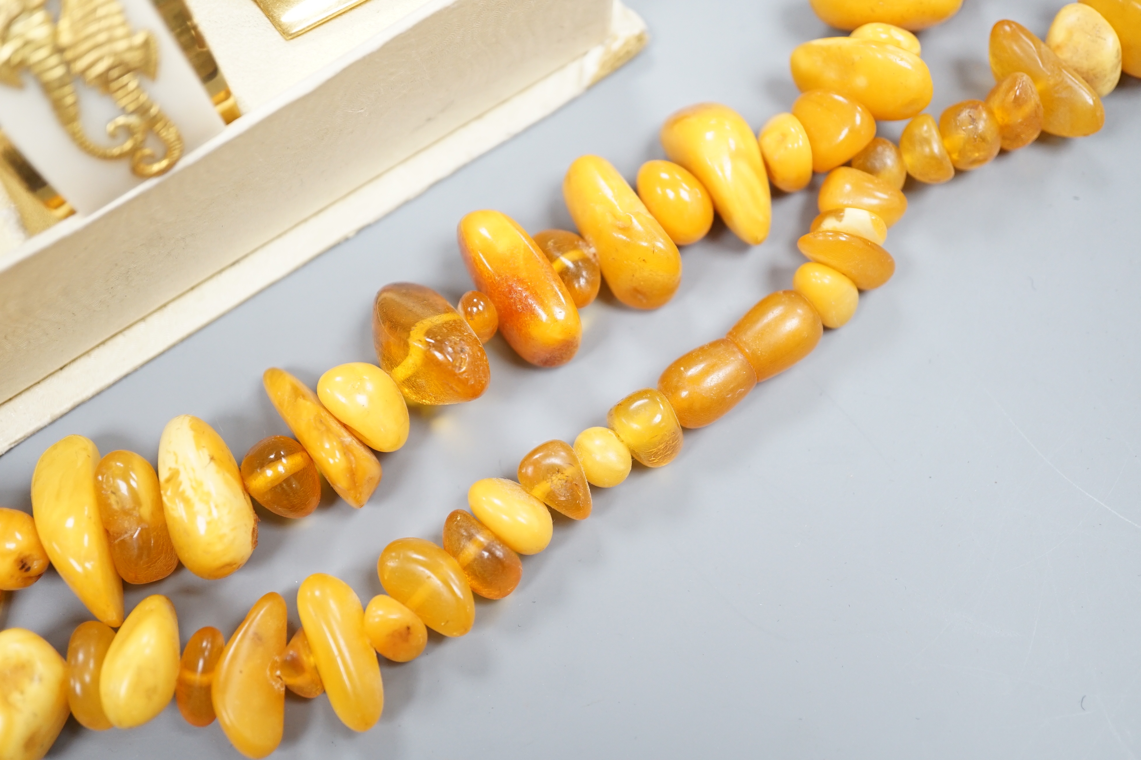 An amber bead necklace, gross 72 grams and a costume bracelet and earclips.